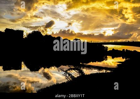Bel tramonto giallo con le nuvole sul fiume Arno a Firenze, Italia Foto Stock