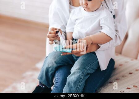 Madre e bambino strofinano le mani con salviette disinfettanti, come pulire le mani, come sedersi in quarantena, assistenza sanitaria Foto Stock