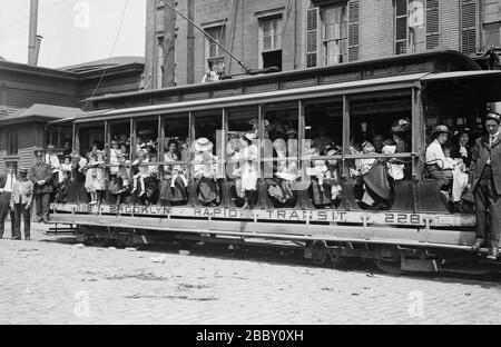 Madri e loro figli in trolley car che si dirigono al traghetto che li ha portato a Sea Breeze, Coney Island, in un viaggio sponsorizzato dalla Fresh Air Home della New York Association per migliorare le condizioni dei poveri Foto Stock