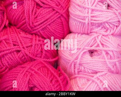 Palline rosa di filo di lana materiale per artigianato tessile hobby, colorato trama astratto sfondo Foto Stock