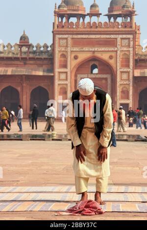 Locali di uomo in piedi nel cortile della Jama Masjid in Fatehpur Sikri, Uttar Pradesh, India. La moschea è stata costruita nel 1648 dall'imperatore Shah Jahan e ded Foto Stock