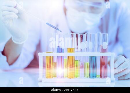 Il medico scienziato studia il test di reazione chimica molti campioni in provetta. Lavorando con il test di formula della medicina in laboratorio medico Foto Stock