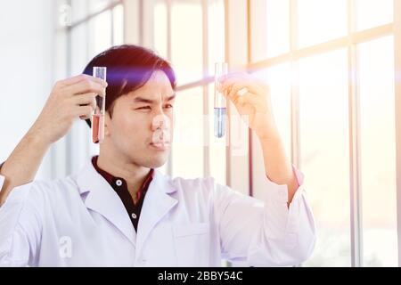 Scienziato di successo scoprire nuova formula di farmaco a scelta selezionare un buon liquido chimico in laboratorio di scienza medica Foto Stock