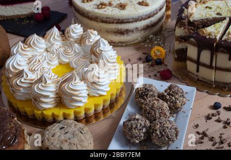 Varie torte su tavola di legno. Assortimento di torte per celebrazioni. Compleanno Foto Stock