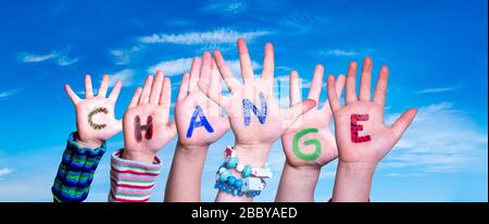 Mani dei bambini che costruono il cambiamento di parola, cielo blu Foto Stock