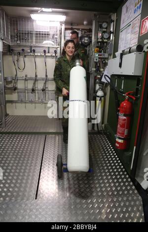 01 aprile 2020, Sassonia-Anhalt, Blankenburg: Il tenente Sahin Seray ordina bombole di ossigeno in un impianto mobile per la produzione di ossigeno medico presso il Centro di approvvigionamento e riparazione delle forze armate tedesche, presso il Sergente Anton Schmid Barracks. L'impianto è una delle due unità mobili che filtrano l'ossigeno dall'aria ambiente. L'ossigeno ottenuto viene riempito sotto pressione in bottiglie da 2 a 50 litri. Nel corso della crisi corona, questo impianto fornisce riserve aggiuntive del gas salvavita. L'ossigeno viene utilizzato principalmente nei cinque ospedali della Bundeswehr in Germania. Gli ospedali forniscono il 70% Foto Stock