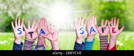 Kids Hands Holding Word Stay Safe, erba Meadow Foto Stock