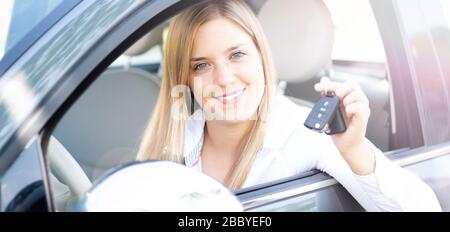 La giovane donna mostra con orgoglio le chiavi della sua prima auto Foto Stock