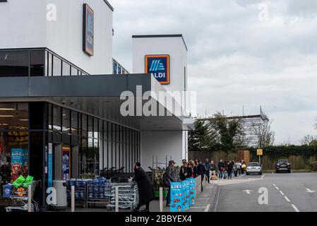 Gli acquirenti che fanno la coda fuori dal superstore Aldi a Westcliff on Sea durante il confinamento per l’epidemia di COVID-19 Coronavirus. Distanziamento sociale Foto Stock