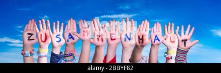 Kids Hands Holding Word Zusammenhalt significa stare insieme, Blue Sky Foto Stock