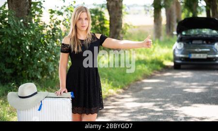 Una giovane donna si rompe con la sua auto Foto Stock