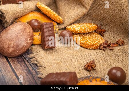 Torte al cioccolato, biscotti, bagel e pezzi di cioccolato su sfondo di legno. Primo piano Foto Stock