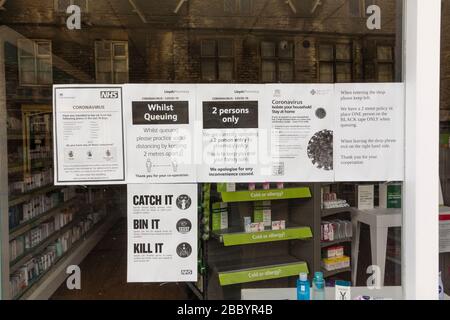 Avviso per gli acquirenti circa il distanziamento sociale sulla finestra di farmacia, Tetbury, Gloucestershire, Regno Unito Foto Stock