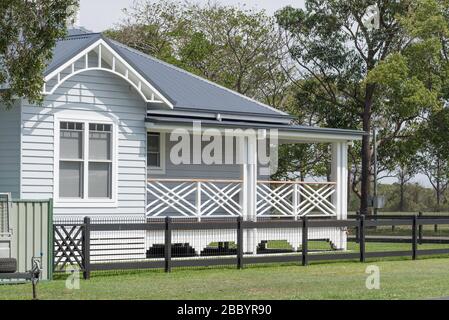 Un singolo livello di casa in stile Federation bungalow con una recinzione postale e ferroviaria nella città costiera di Tea Gardens, New South Wales in Australia Foto Stock