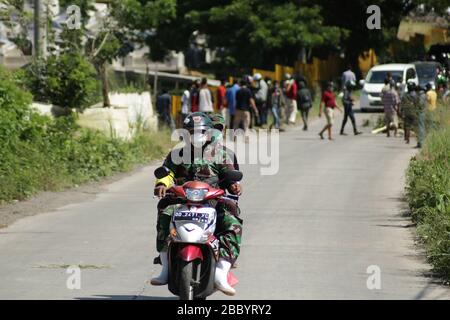 Makassar, Sulawesi meridionale, Indonesia. 2nd Apr, 2020. I membri delle forze Armate indonesiane girarono a cavallo delle moto dopo decine di residenti al confine tra Makassar e Gowa, provincia di Sulawesi meridionale, l'Indonesia intercettò un corteo di pazienti sotto controllo (PDP) a causa di Covid-19, installando blocchi di legno nel mezzo della strada. Questi residenti proibiscono ai corpi dei pazienti di Covid-19 di essere seppelliti nella sua zona. Ad oggi, il governo indonesiano ha aggiornato i dati sui pazienti infetti da Covid-19 a 1,790, con 170 decessi. Credito: Herwin Bahar/ZUMA Wire/Alamy Live News Foto Stock