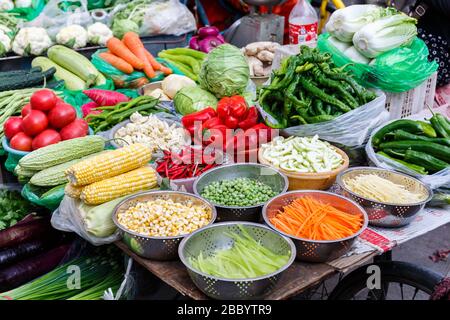 Stand di verdura in un mercato a Lhasa, Tibet (Cina, Asia). Molte verdure diverse sono in vendita: Pepe verde, piselli verdi, teste di insalata, Foto Stock