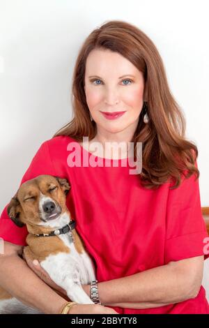 Donna seduta che posa con il suo cane dolce Foto Stock