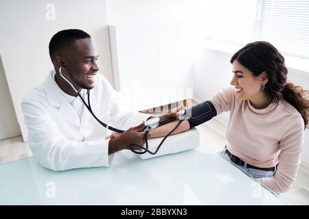 Close-up di medico pazienti di misurazione della pressione sanguigna con uno stetoscopio Foto Stock