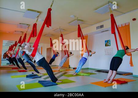 Lezione di yoga aerea in corso Foto Stock