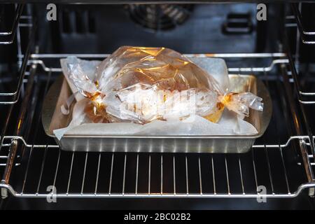 La carne viene cotta in un manicotto su un foglio di lamiera nel forno. Foto Stock