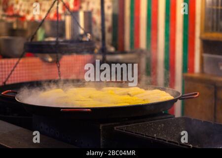 Street food. Granoturco bollente in un grande calderone, e acqua bollente spessa sale sopra acqua bollente. Sulla strada in città. Foto Stock