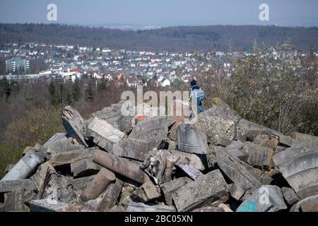 Stoccarda, Germania. 02nd Apr, 2020. Un ragazzo si arrampica sui detriti di Birkenkopf, sullo sfondo si può vedere il quartiere di Stoccarda di Botnang. Più di 15.000.000 metri cubi di macerie sono stati depositati sulla collina dopo la seconda guerra mondiale. La montagna è conosciuta popolarmente come 'Monte Scherbelino'. Credito: Marijan Murat/dpa/Alamy Live News Foto Stock