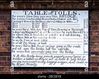 Tabella dei pedaggi esposti sul casello all'estremità sud del ponte di ferro a Ironbridge, Shropshire, Regno Unito. Foto Stock