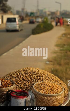 Street, fornitore di arachidi attende i clienti di Hatirjheel nella capitale, Bangladesh. Foto Stock