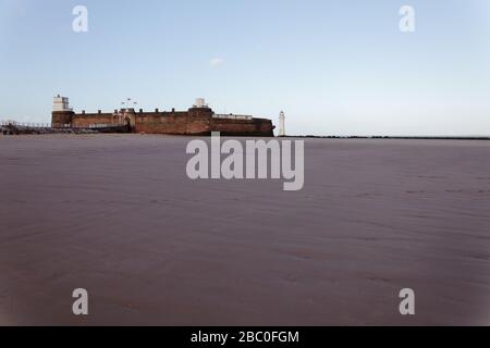 Il faro e il faro di Fort Perch Rock si sono visti attraverso le sabbie di New Brighton sul Wirral Foto Stock