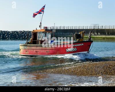 Pesca in barca (Pioneer NN200) sbarcando sulla spiaggia a Hastings, East Sussex, UK, dopo un viaggio di pesca Foto Stock