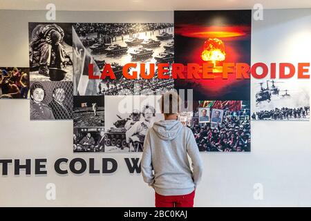 TEENAGER CHE GUARDA UN PANNELLO CHE RACCONTA I MOMENTI IMPORTANTI DELLA GUERRA FREDDA, MOSTRA SULLE PARETI DEL CAEN MEMORIAL, CALVADOS (14), NORMANDIA, FRANCIA Foto Stock