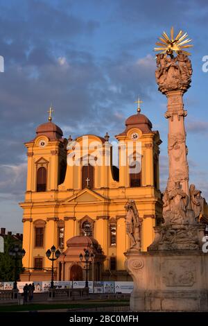 Romania, Timis, Timisoara, Cattedrale cattolica e colonna della Santissima Trinità (monumnet alla peste) su Piata Uniri al tramonto, città vecchia. Foto Stock