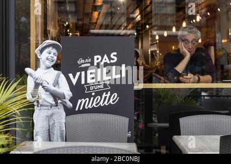 FACCIATA DELLA PANETTERIA AU PAIN DORE, 'ON N'A PAS VIEILLI D'UNE MIETTE' (NON ABBIAMO INVECCHIATO DA UNA BRICIOLA') CON UN ANZIANO GENTILUOMO SULLO SFONDO, CHEMIN DE LA COTE DES NEIGES, MONTREAL, QUEBEC, CANADA Foto Stock