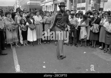 Notting Hill Carnival Londra 1980s. Un gruppo di adolescenti si levano in cerchio per guardare un uomo che balla da solo. 1981 UK HOMER SYKES Foto Stock