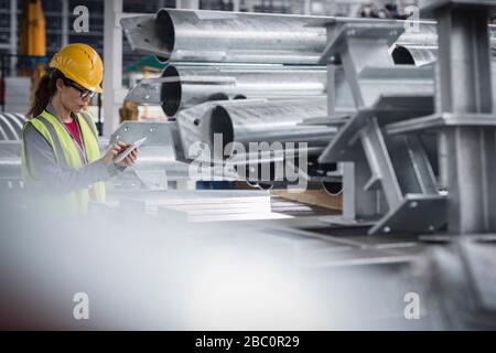 Supervisore femminile con tablet digitale in fabbrica d'acciaio Foto Stock