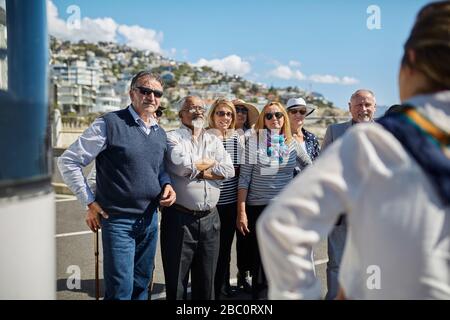 Turisti anziani attivi che ascoltano la guida turistica Foto Stock