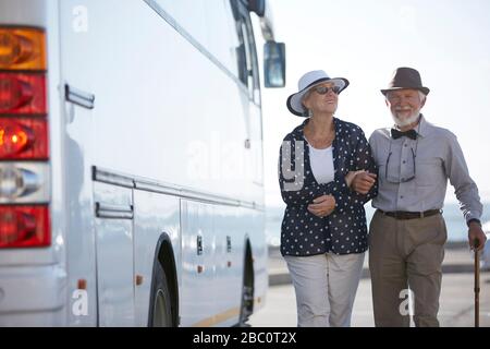 Sorridi turisti attivi in coppia a piedi lungo l'autobus Foto Stock