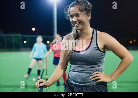 Sorridente giovane donna campo hockey su campo Foto Stock