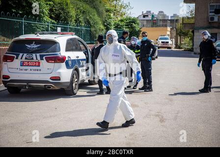 Bnei Brak, Israele. 02nd Apr, 2020. Un poliziotto israeliano in tuta è visto nei perimetri del Ponevezh Yeshiva, un'istituzione ebraica che si concentra sullo studio dei testi religiosi tradizionali, dove gli ebrei ortodossi insistono a portare avanti la loro preghiera nonostante il blocco imposto in mezzo alla pandemia del coronavirus. Credit: Ilia Yefimovich/dpa/Alamy Live News Foto Stock