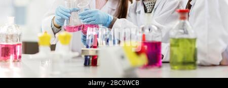 Liquido in flaconi, provette e becher in classe di laboratorio scientifico Foto Stock