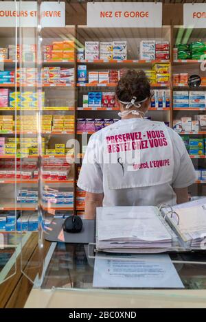 SALVA NOI, SOGGIORNO A CASA, DIPENDENTE DELLA FARMACIA DIETRO UNO SCHERMO IN PLEXIGLASS, MISURE SANITARIE PREVENTIVE MESSE IN ATTO PER L'EPIDEMIA DI CORONAVIRUS, RUGLES, NORMANDIA, FRANCIA Foto Stock