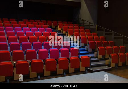 Posti a sedere rossi in auditorium vuoto Foto Stock