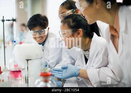 Studenti curiosi che osservano la reazione chimica, conducendo esperimenti scientifici in classe di laboratorio Foto Stock