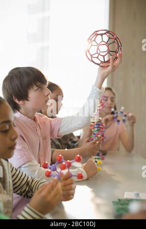 Studente ragazzo concentrato che esamina la struttura molecolare in classe di laboratorio Foto Stock