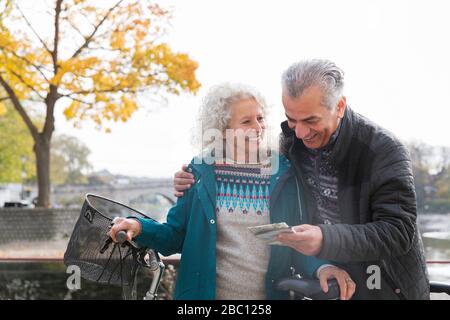 Coppia senior avventurosa con biciclette che guardano la mappa Foto Stock