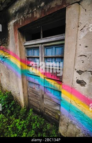 Spagna, Provincia di UNA Coruna, San Saturnino, Arcobaleno dipinta attraverso le porte di casa abbandonata Foto Stock