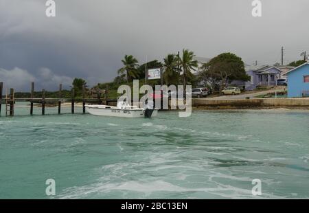 Barraterre, Great Exuma Cays - Gennaio 2018: Ampio scatto del molo di legno a Barraterre, George Town, con una barca veloce ormeggiata in una mattina tempestosa. Foto Stock