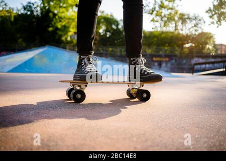 Giovane donna in piedi sullo skateboard Foto Stock