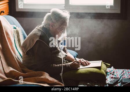 Senior donna mediante inalatore a casa Foto Stock