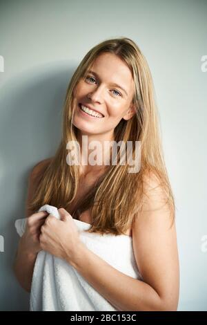 Ritratto di giovane donna felice avvolto in un asciugamano Foto Stock